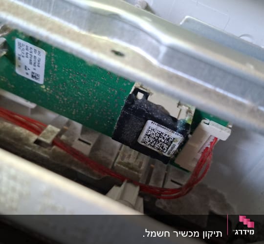 כרטיס אלקטרוני שרוף במכשיר חשמל ביתי במהלך אבחון ותיקון